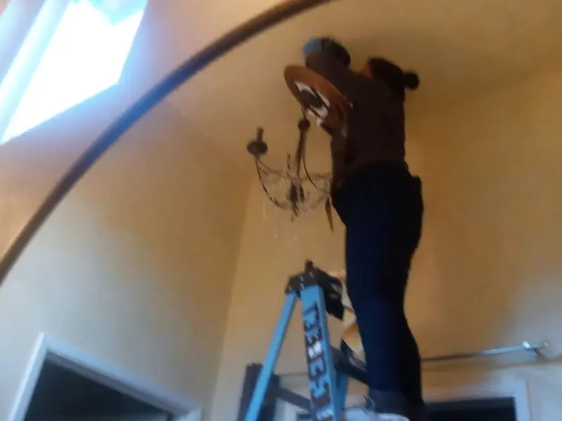 Electrician installing a chandelier in a Contra Costa Centre residence